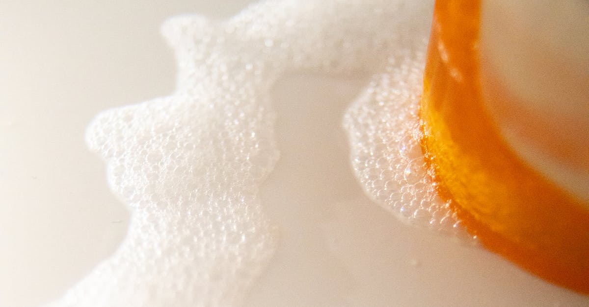 Does bubbly froth mean my vinegar batch needs trashed? - High angle of pile of colorful soaps near foam flow with small bubbles on white surface