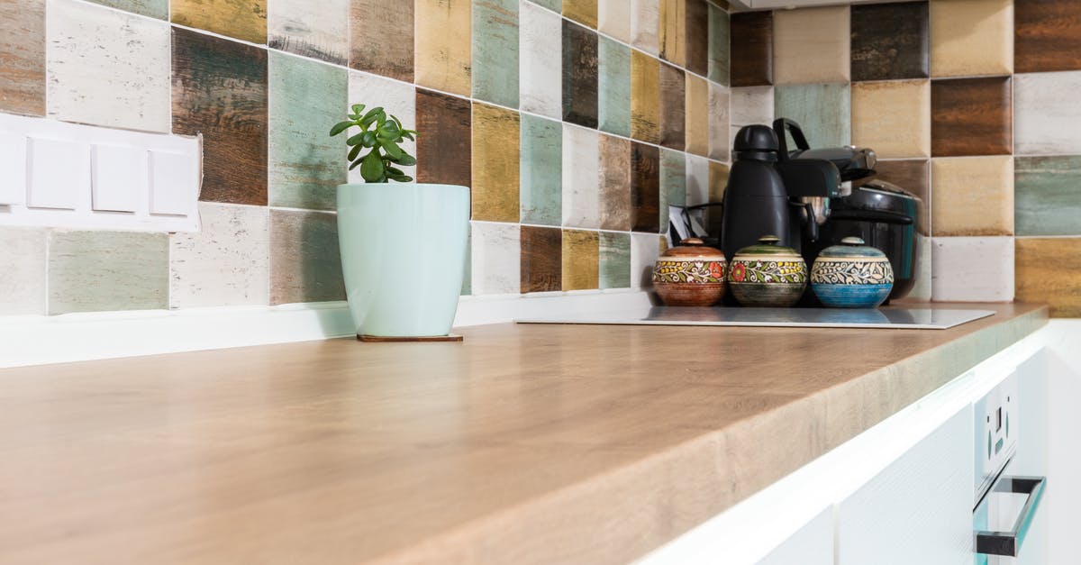 Does ceramic non-stick cookware "fail", and if so, how? - Interior of light kitchen furnished with wooden counter with multicolored tiled backsplash and various dishware