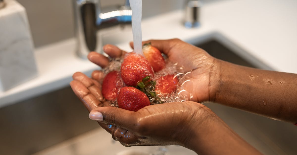 Does dirt sink or rise in boiling water? - Person Washing Red Strawberries