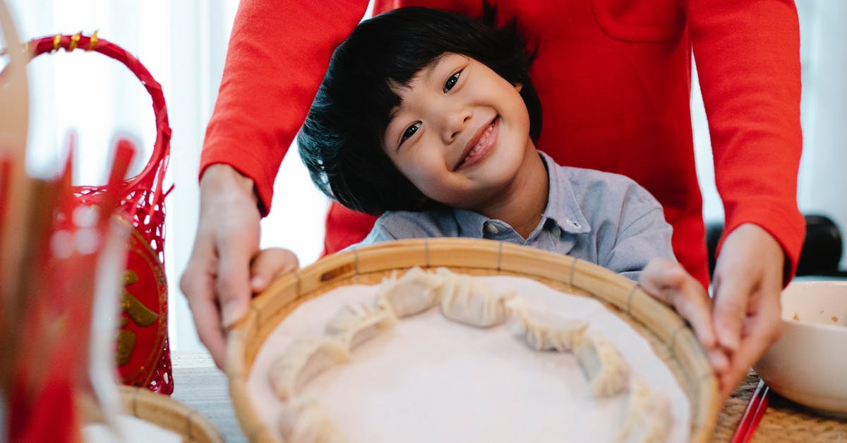 Does food steamer require ventilation - Smiling Asian boy showing handmade dumplings