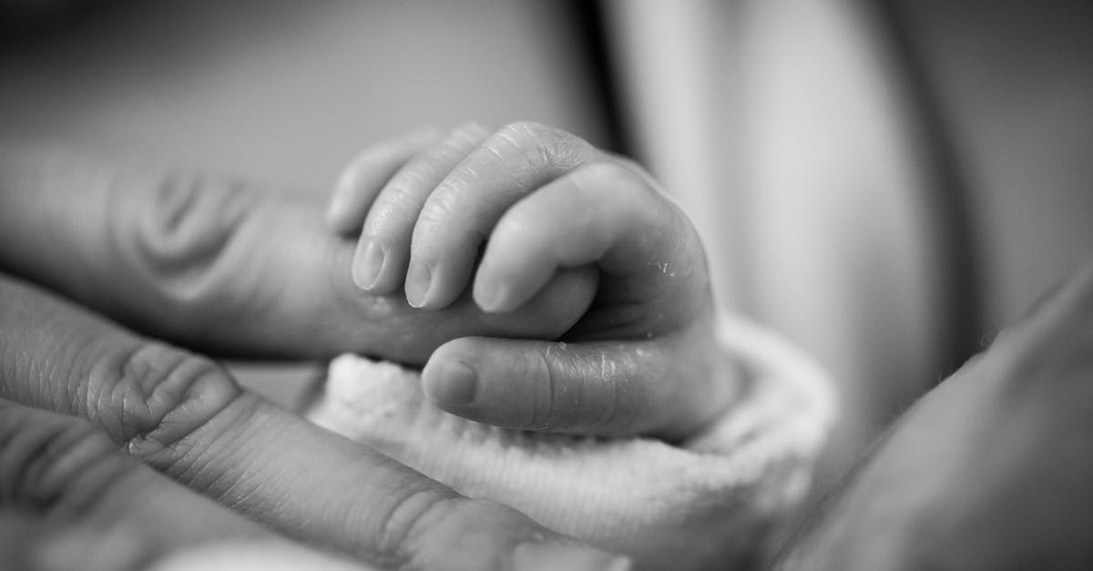 Does freezing non-freezable liquids affect life span - Grayscale Photography of Baby Holding Finger