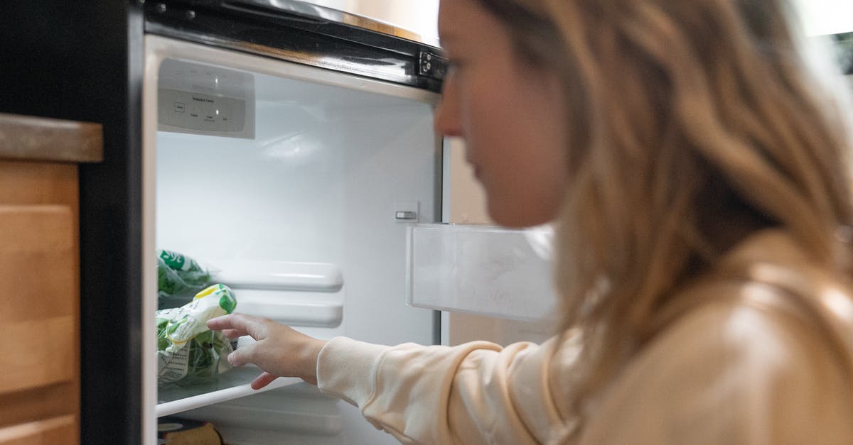 Does having spoiling food in your fridge cause other food to spoil faster? - Woman in Brown Long Sleeve Shirt Holding Green Vegetable