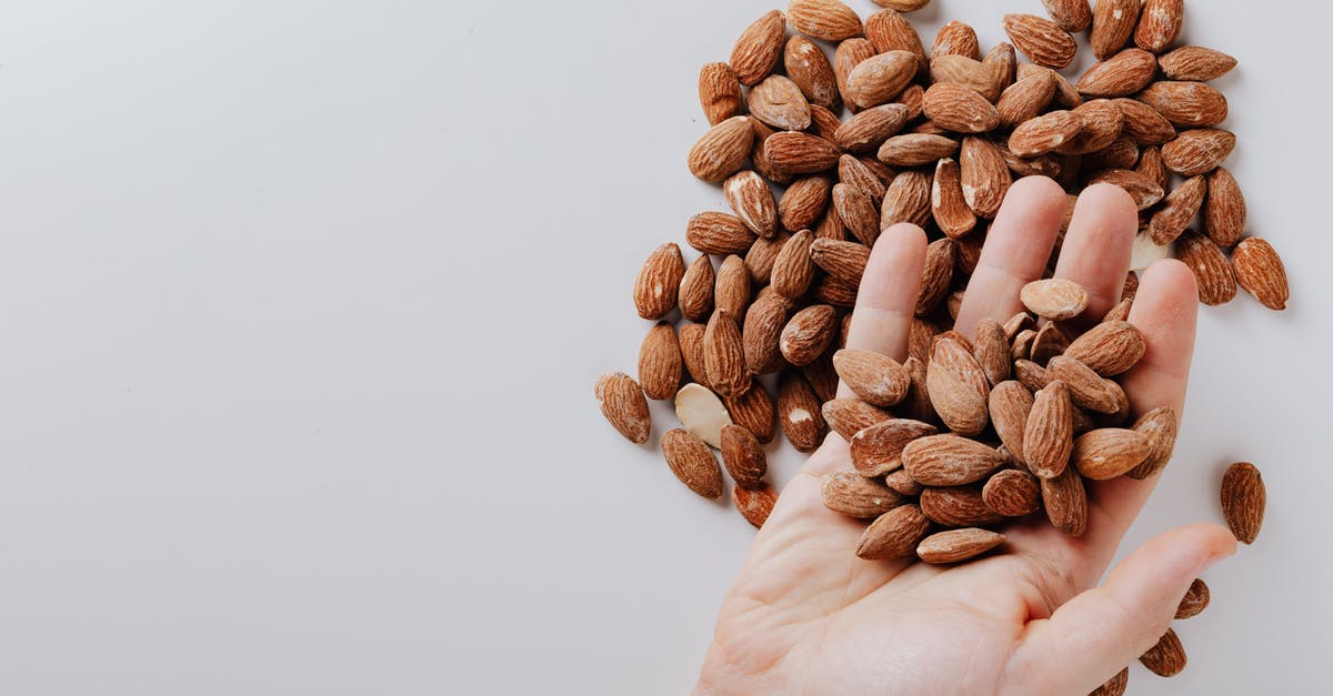 Does it take more energy to maintain a higher cooking temperature? - From above of anonymous male taking tasty organic almonds from pile of nuts placed on white background isolated illustrating healthy food concept Does it take more energy to maintain a higher cooking temperature? - From above of anonymous male taking tasty organic almonds from pile of nuts placed on white background isolated illustrating healthy food concept