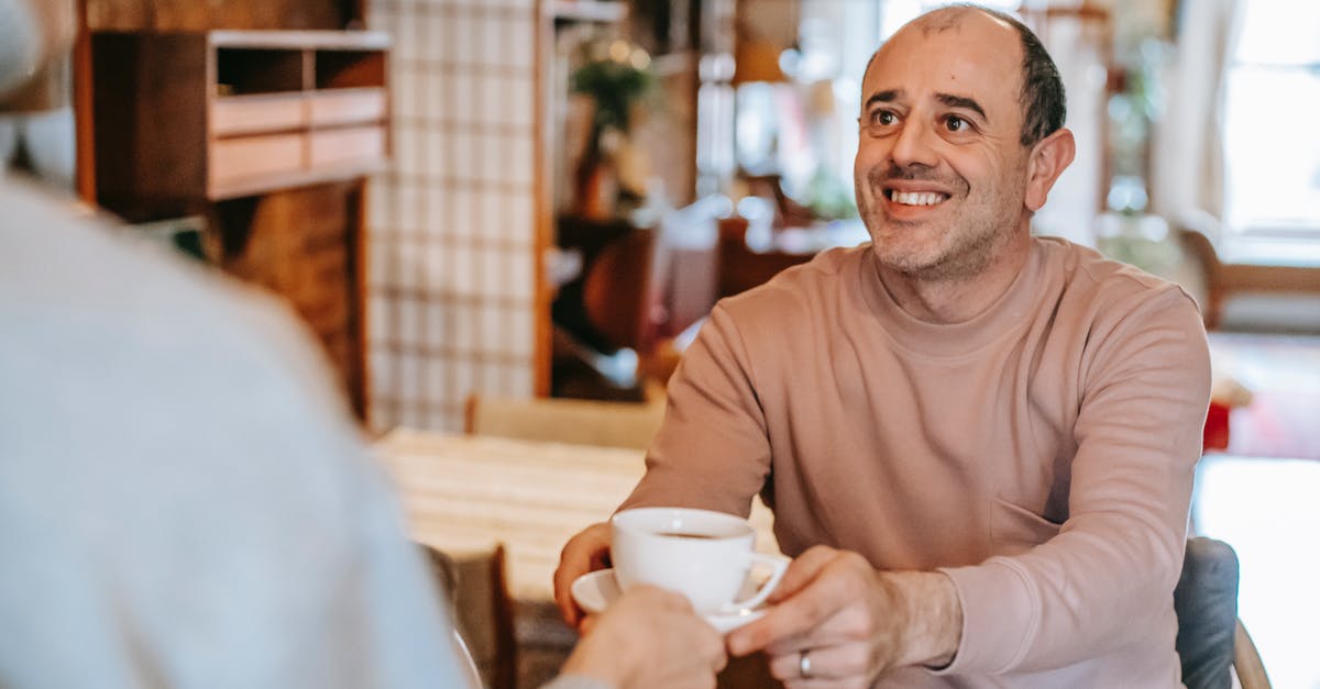 Does it take more energy to maintain a higher cooking temperature? - Unrecognizable woman giving coffee cup to positive ethnic husband Does it take more energy to maintain a higher cooking temperature? - Unrecognizable woman giving coffee cup to positive ethnic husband