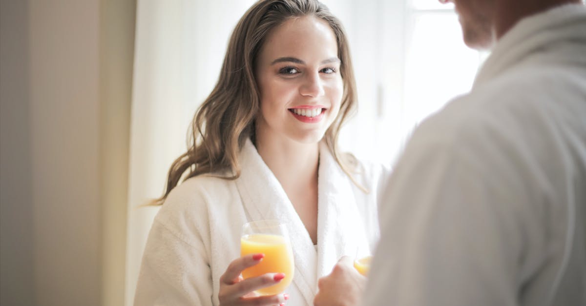 Does milk tenderize meat? - Smiling woman with glass of fresh juice at home