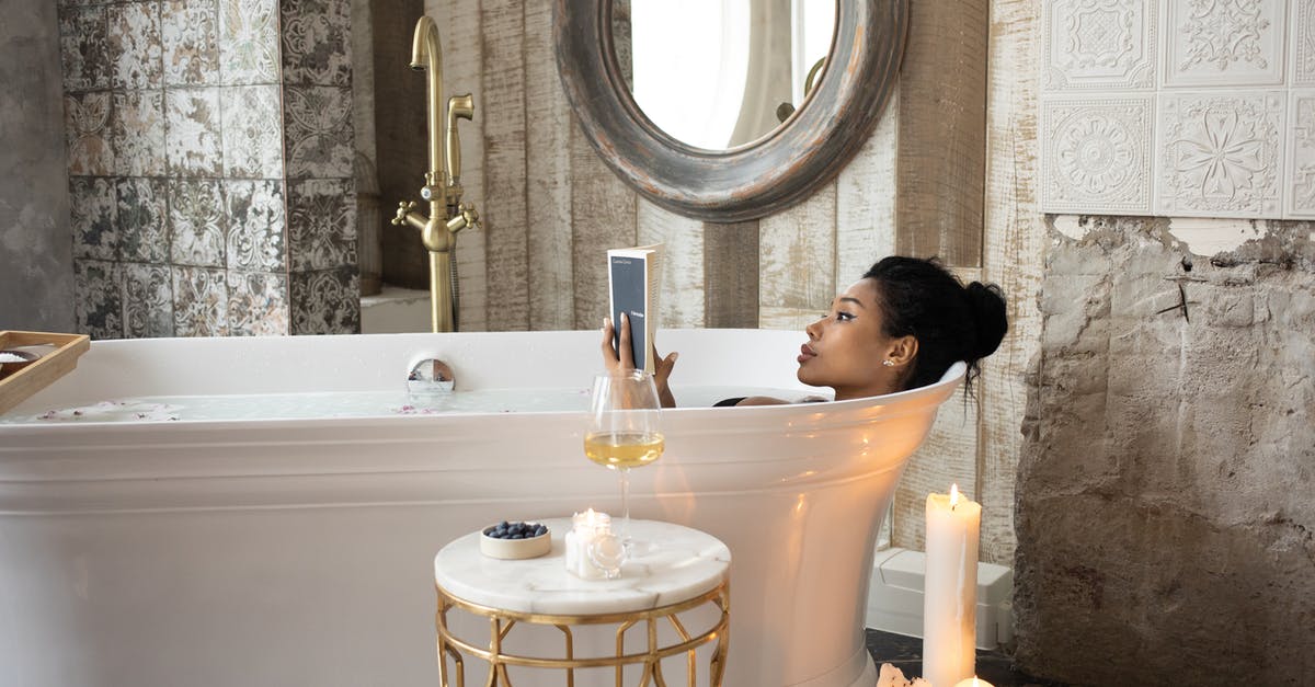 Does pasta boiled in tap water absorb chemicals? - Side view of young African American female reading book while lying in bathtub and enjoying spa procedure with wine glass on small marble table and aroma candles