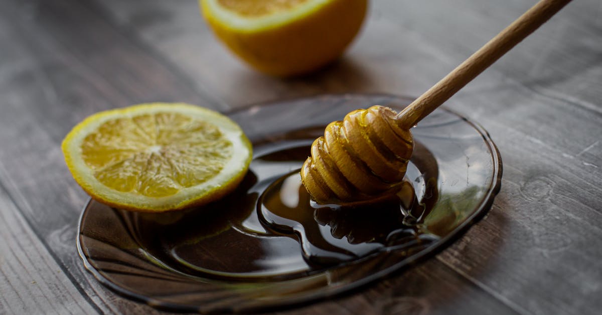 Does raw honey need to be prepared before consumption? - Honey dipper placed on saucer with lemon slice