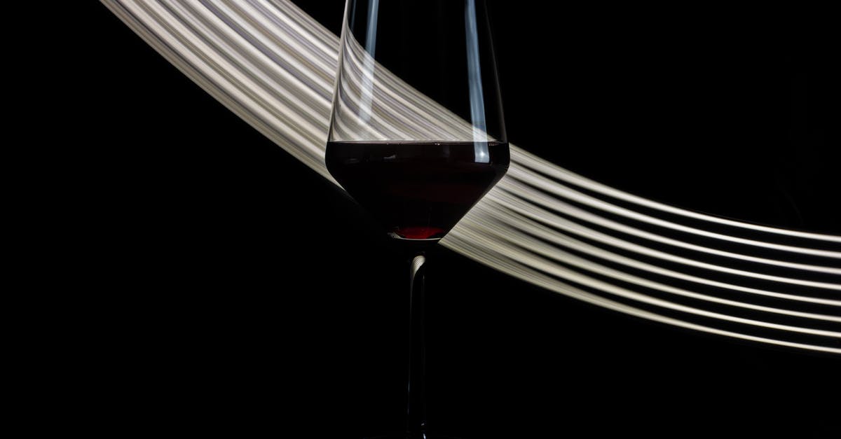 Does red wine vinegar and red vinegar taste same? - Wineglass of fragrant exquisite red wine placed against black background with white shiny lines