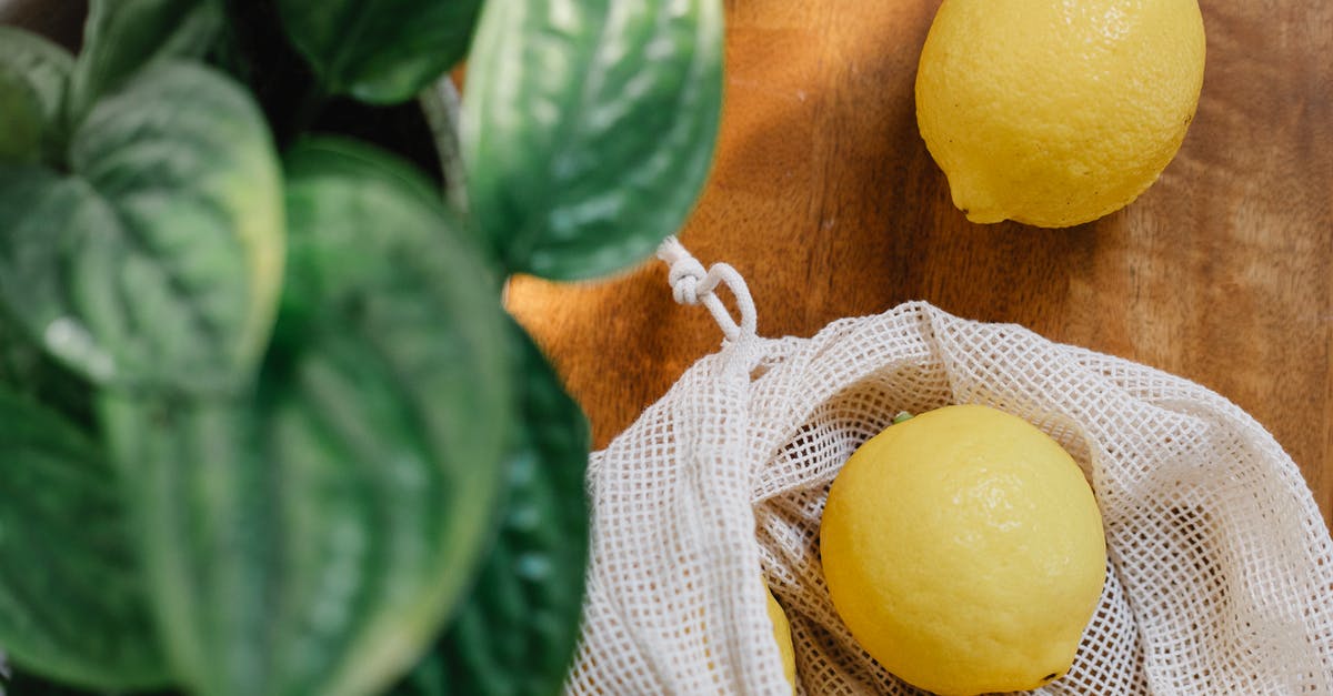 Does ripening banans in a bag with other fruit harm the other fruit? - Fresh lemons placed on wooden table