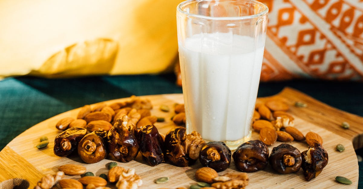 Does soaking almonds have the same effect as blanching and removing the skins when making almond milk? - A Glass of Milk and Mixed Nuts on a Wooden Board
