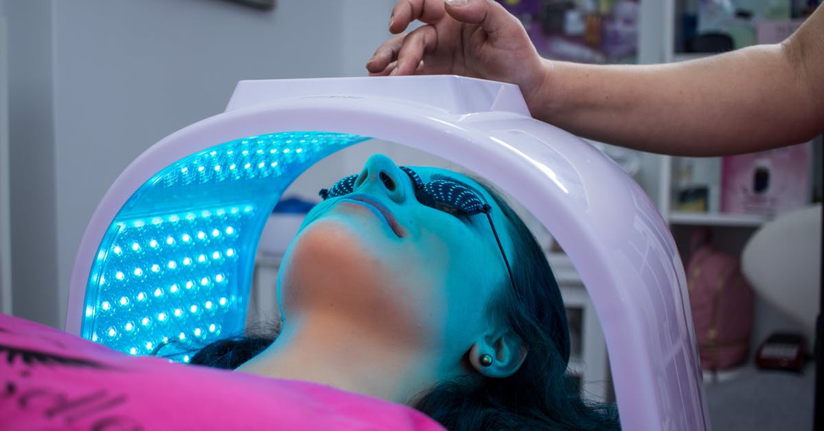 Does soaking in saltwater for 20 mins help cleanse mussels? - Unrecognizable woman with dark hair with pierced ears lying under ultraviolet lamp while visiting contemporary clinic and spending time in modern salon