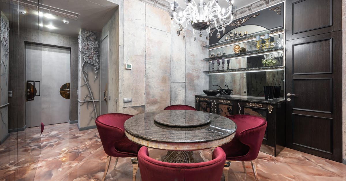 Does the oven door need to be toughened glass? - Interior of modern spacious kitchen with round table and red chairs placed near contemporary counter with kitchenware in stylish apartment