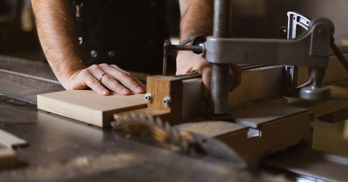 Does the snake method only work on circular grills? - Unrecognizable male master cutting piece of wooden plank while working at sawbench in workshop on blurred background with professional equipment