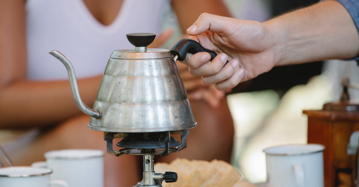 Does turning a gas stove on high move the heat to the outside of the pot? - Crop couple using portable gas stove while preparing coffee at campsite