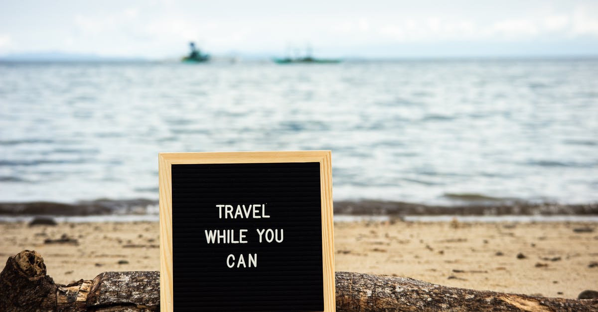 Does water "go bad" in this sense? - Board with Text 'Travel While You Can' Beside Log on the Beach