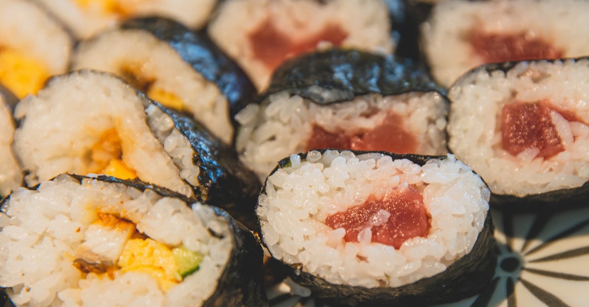 Doubling the ingredient of Japanese cheesecake: more time to cook? - From above of fresh traditional Japanese rolls with rice and raw fish covered with black seaweeds on plate