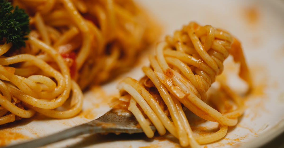 Dough for edible bowls, plates - From above closeup plate and fork with appetizing spaghetti with tomato sauce and herbs served on table during lunch