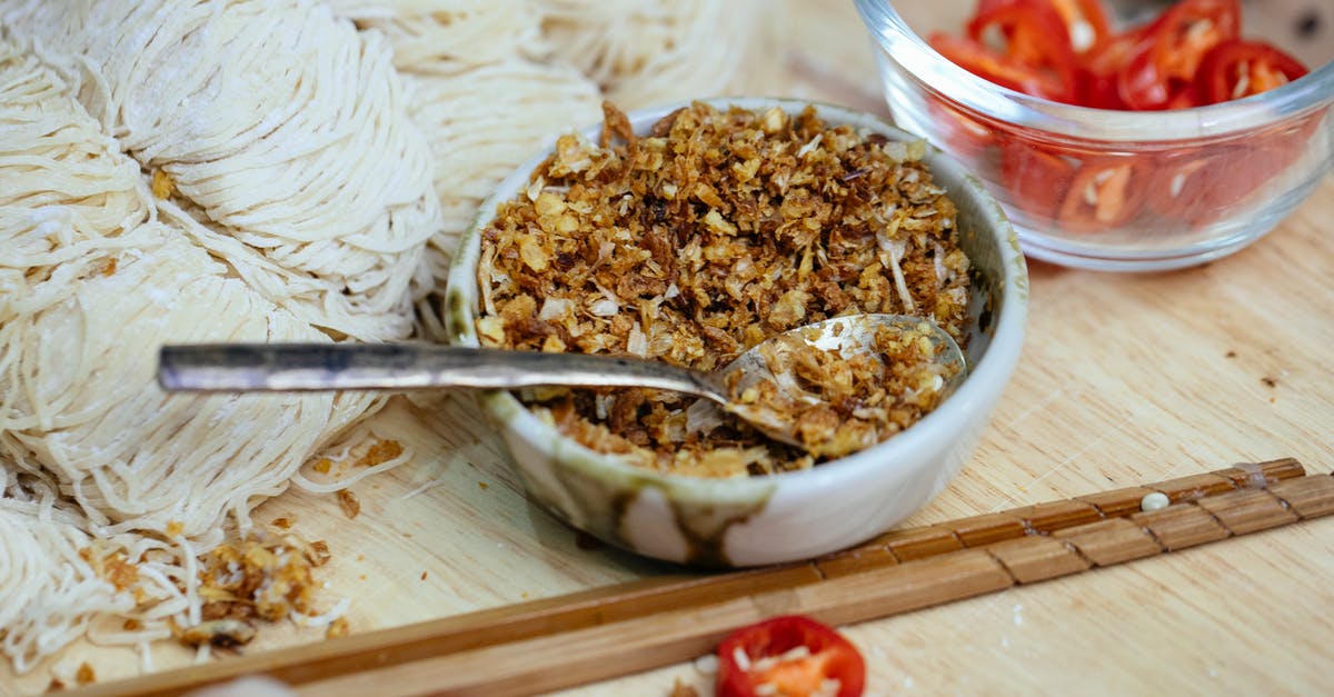 Dough for edible bowls, plates - Bowl of spice placed near uncooked noodles on board