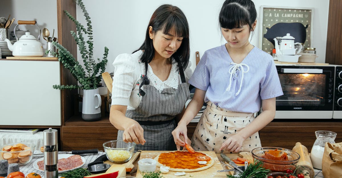 Dough(s) to hold moist oven dish contents - Calm ethnic women cooking pizza