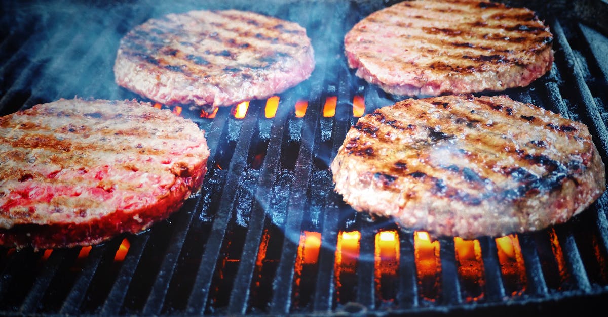 Dry brining burger patties with onions - Shallow Focus Photo of Patties on Grill