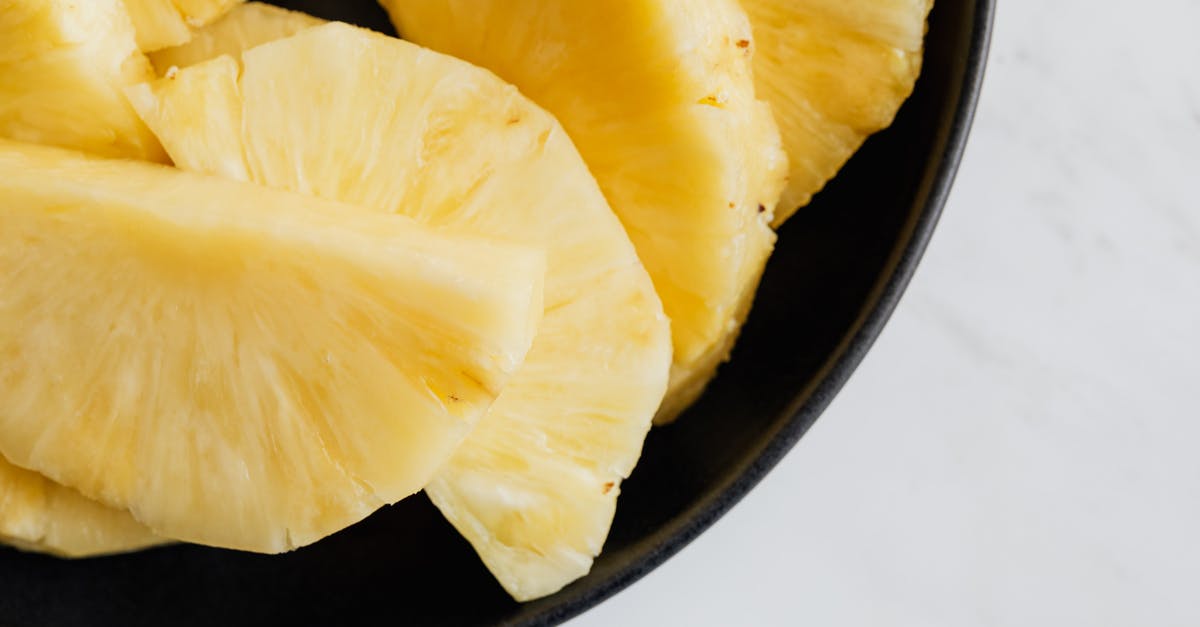 Duck curry with pineapple pieces [closed] - Fresh pineapple slices in black bowl