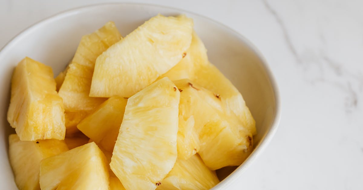 Duck curry with pineapple pieces [closed] - From above of fresh pieces of ripe pineapple served in white deep plate and placed on marble table