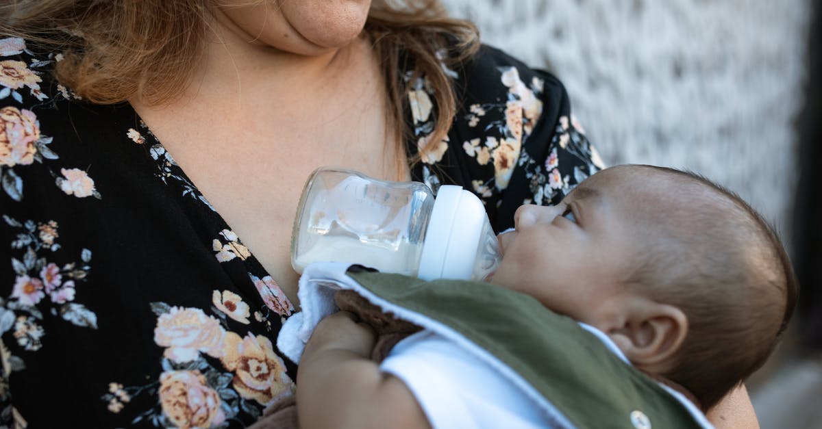 Dutch Baby Disaster! - A Woman in Floral Shirt Carrying a Baby while Drinking Milk