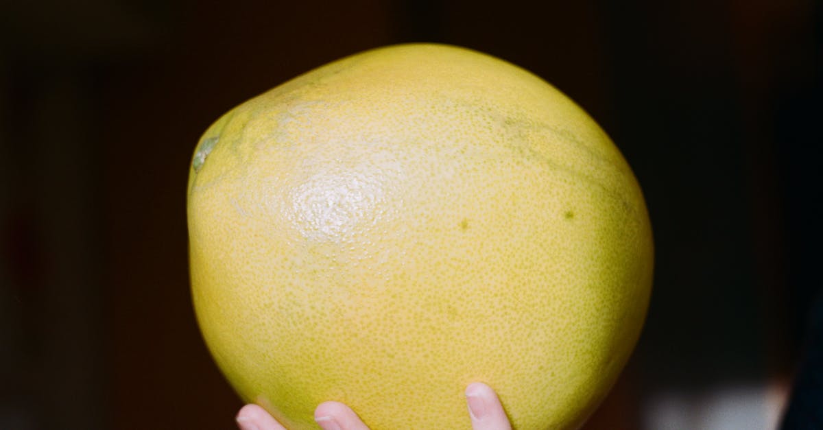 Easiest way to peel pomelos? - Crop person showing bright fresh pomelo fruit