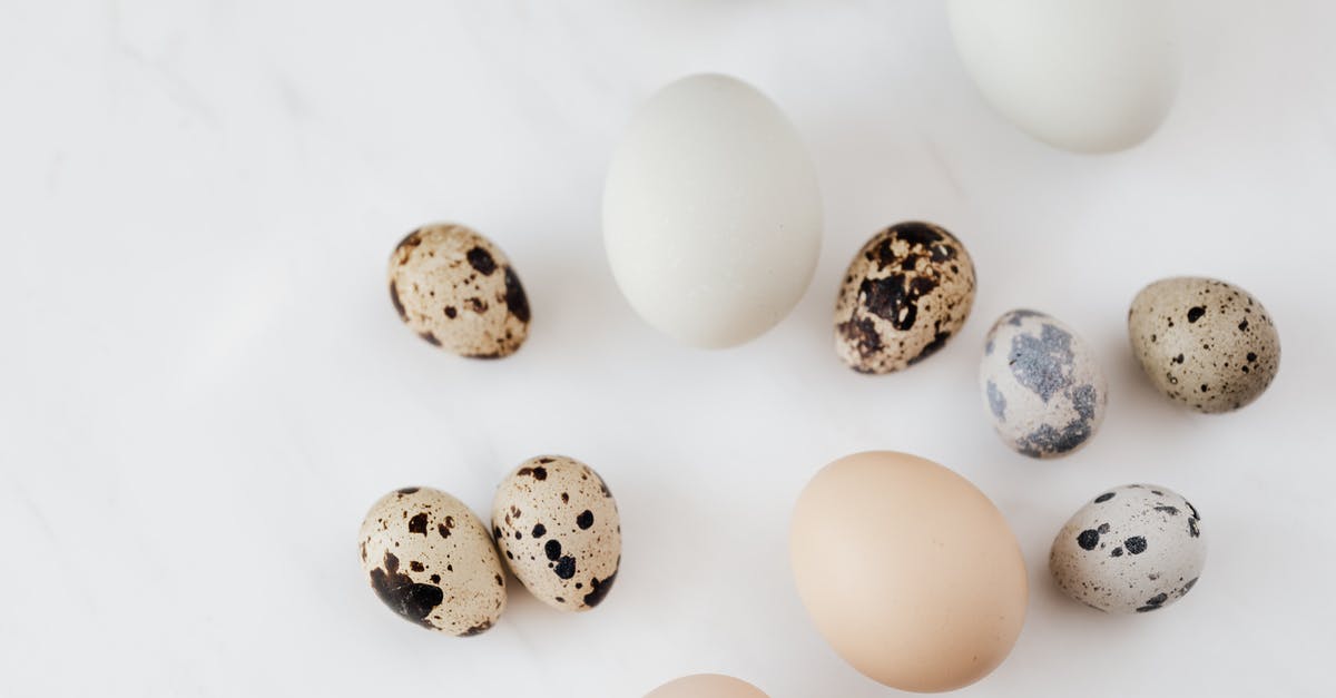 Easy way to trim raw chicken thighs - Top view of fragile quail and chicken eggs scattered on marble surface before cooking