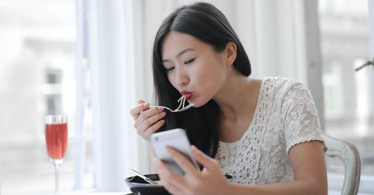 Effect of wine used for deglazing on dish - Asian young female eating noodles at cafe