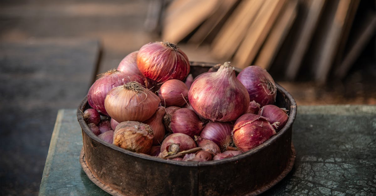 Efficient method to peel onions? [duplicate] - Old bowl with pile of red onions on rustic table