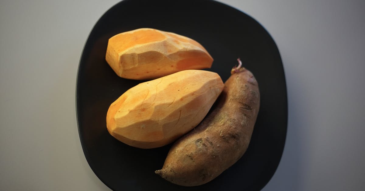 Efficient method to peel raw potatoes - Raw batata potatoes on black plate