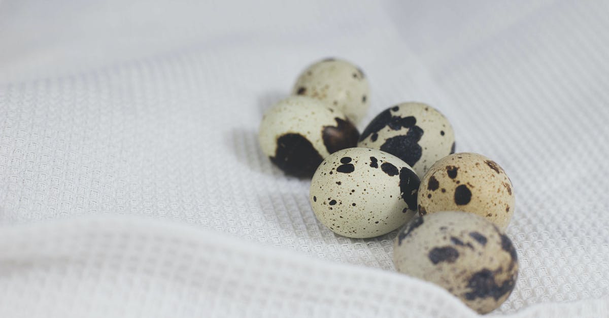 Egg shells speckled after cooking - Quail Eggs on White Fabric