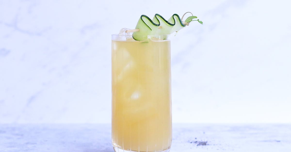 Egg substitute for cookie-flavor syrup - Glass of yummy sour ginger lemonade garnished with cucumber slice and served on light marble table in studio