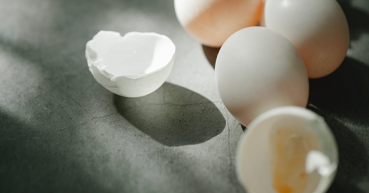 Egg yolk substitute for whole eggs in strata - From above of fresh raw white chicken eggs with broken shells scattered on gray table in kitchen