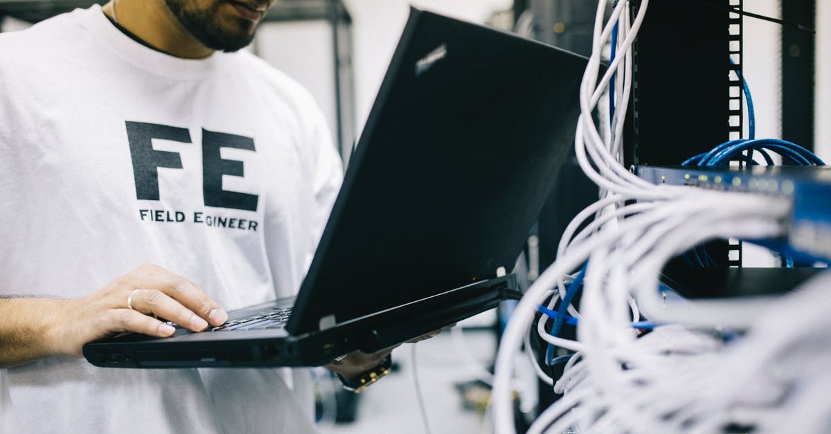 Electric skillet probe control burnt at end - Crop focused Asian engineer in white shirt using modern netbook while working with hardware