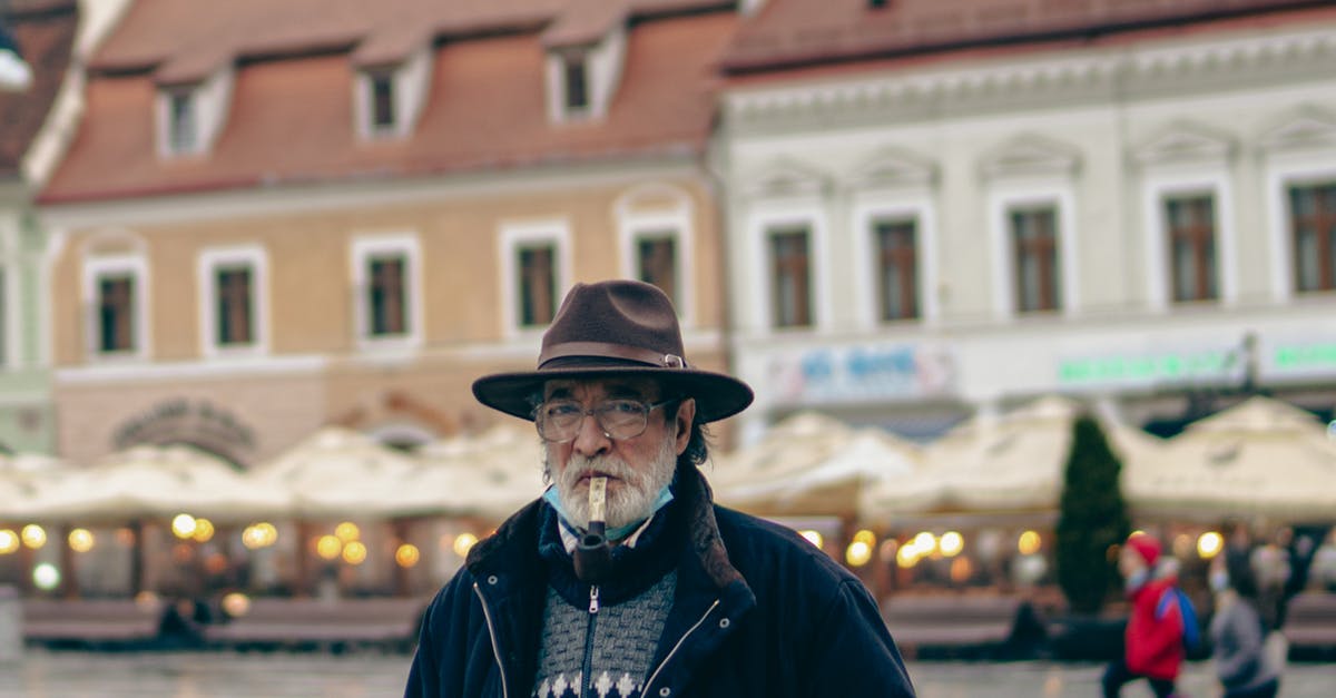 Electric smoker and a charcoal smoker - An Elderly Man Wearing a Brown Fedora Hat