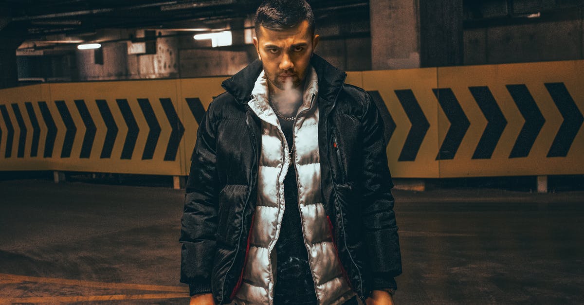 Electric smoker and a charcoal smoker - Man Wearing Puffer Jackets Blowing Smoke from a Cigarette