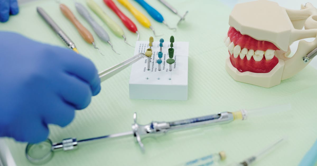 Enameled cast iron vs stainless steel for acids - From above of crop faceless orthodontist in latex gloves and tweezers working at medical table with cast jaw and set of syringes near periodontal scalers
