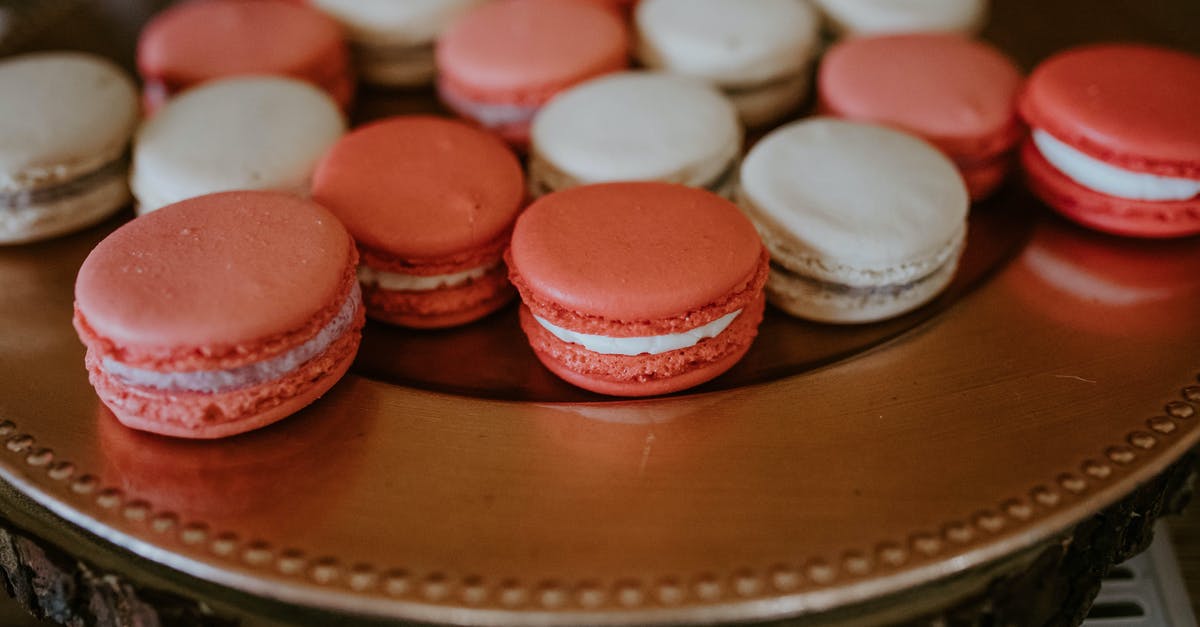 Enlarging from a home bakery to a commercial bakery - From above of colorful macaroons with cream placed on round stand for sweet treat