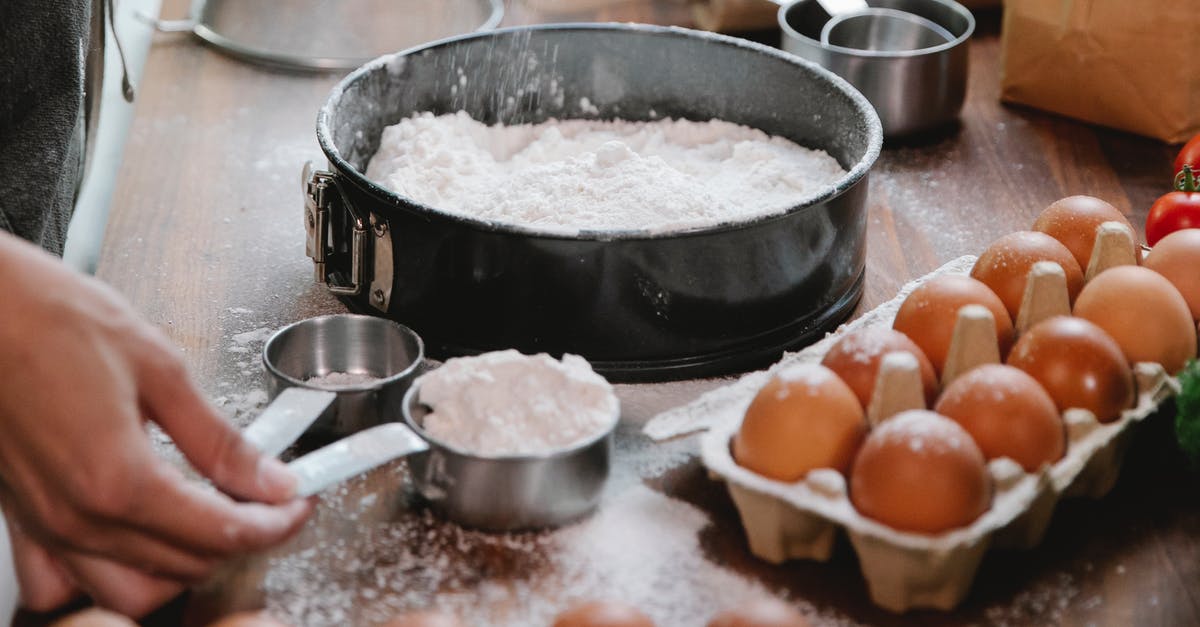 Enzymatic reactions that happen when water and wheat flour is mixed? - High angle of crop anonymous cook adding flour into baking dish while preparing pastry in kitchen