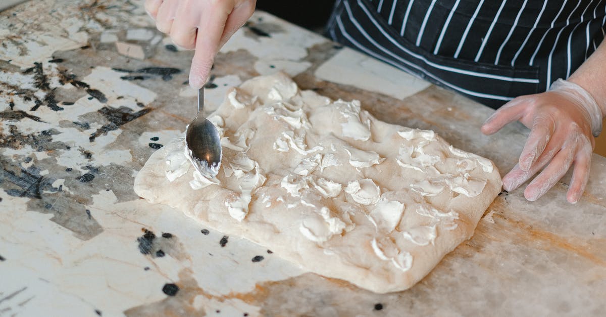 Excess oil / holes in cheese when baking pizza - A Chef Spreading Cheese over a Dough