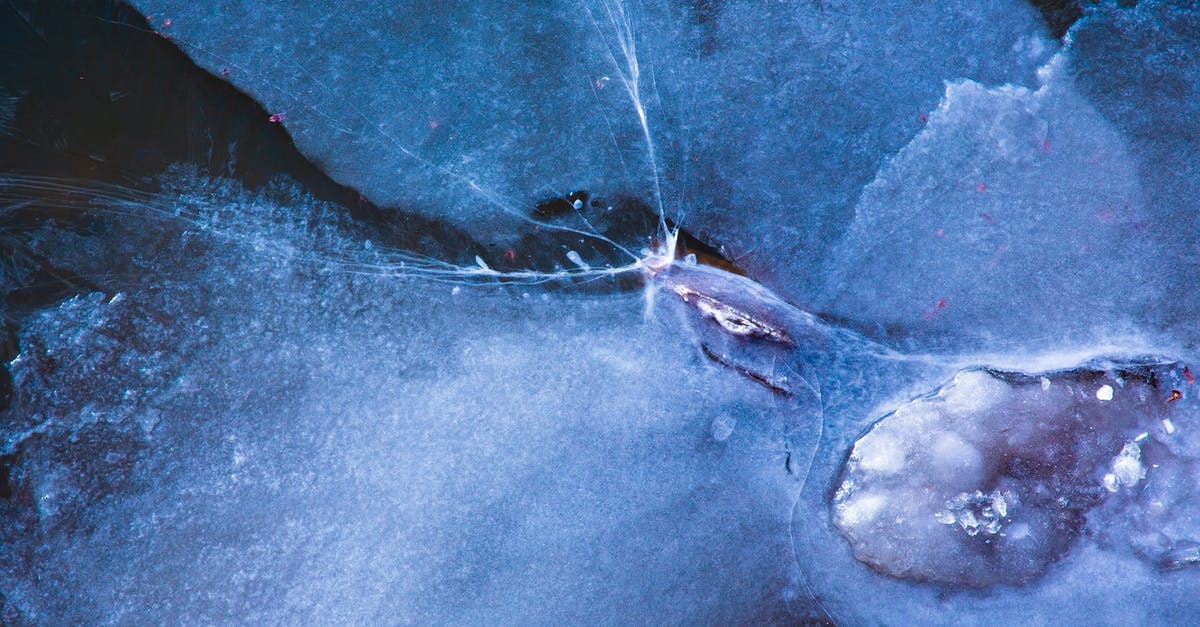 Extent of poultry denaturing via freezing(ice crystal formation)? - Full frame textured background of blue ice water with uneven bristly surface covered with cracks