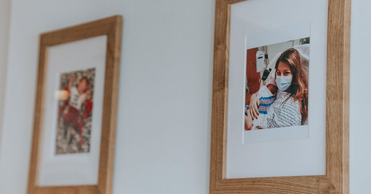 Extremely tender beef at hospital - Framed photo of young woman in medical musk hugging newborn baby while lying on bed in hospital after childbirth hanging on white wall