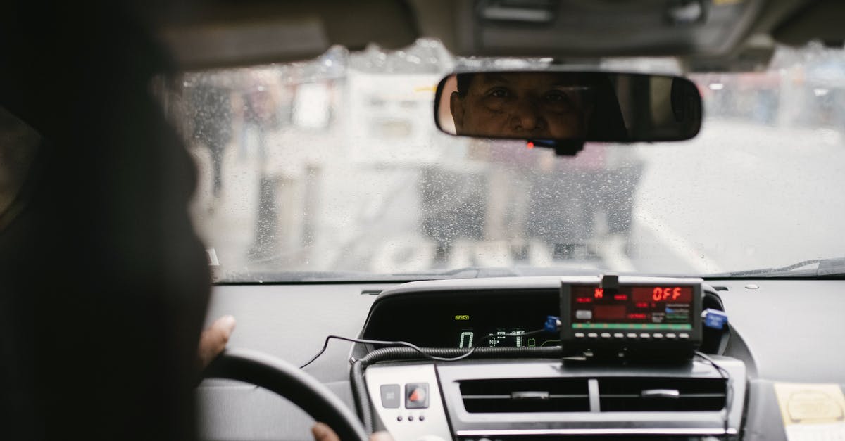 Fast meringue technique - Back view of man reflecting in mirror while driving along street in city on urban background in soft daylight