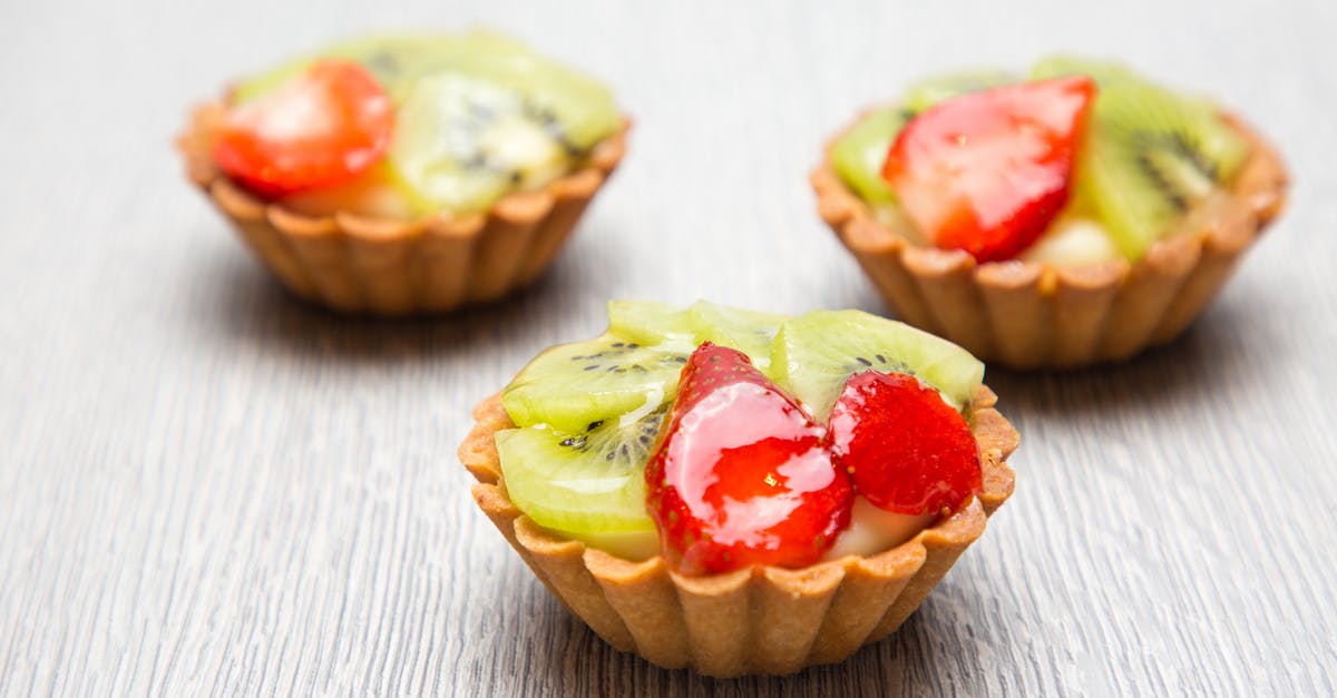 Filling tart with beans/rice for baking - Close-up Photography of Three Kiwi Topped Tarts