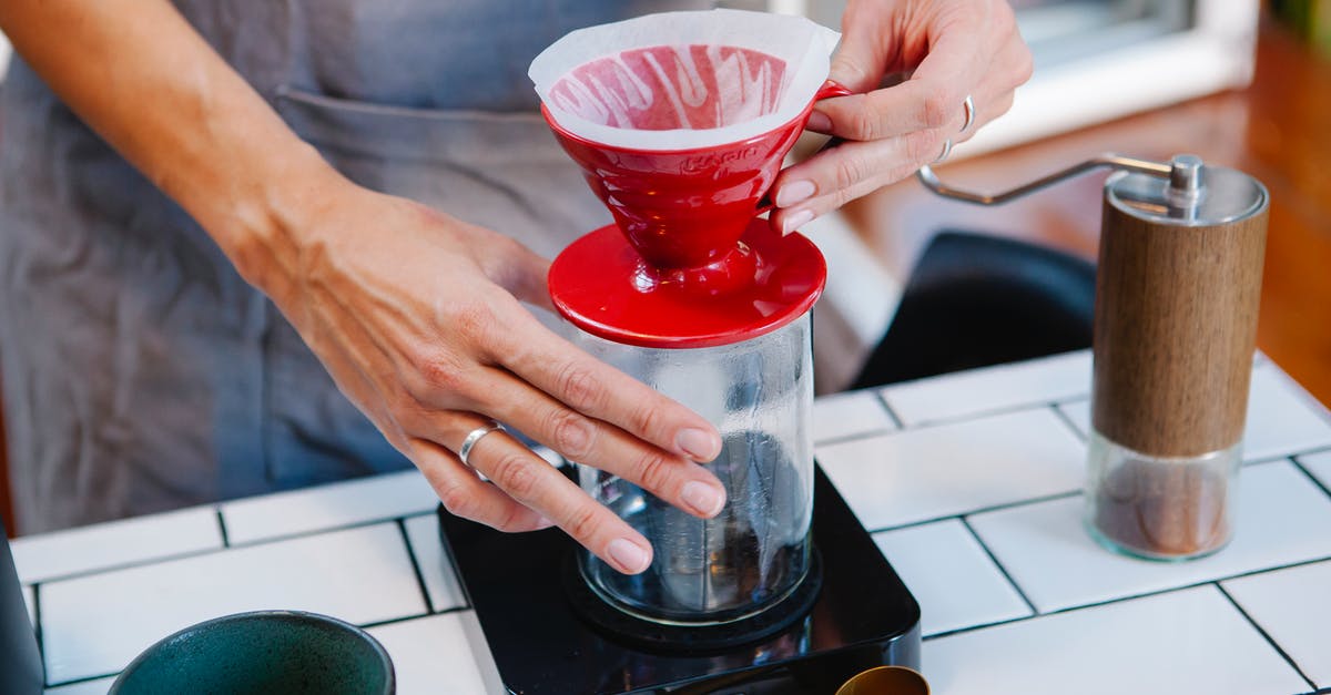 Filtering home-rendered lard - Woman barista preparing fresh alternative coffee in cafe