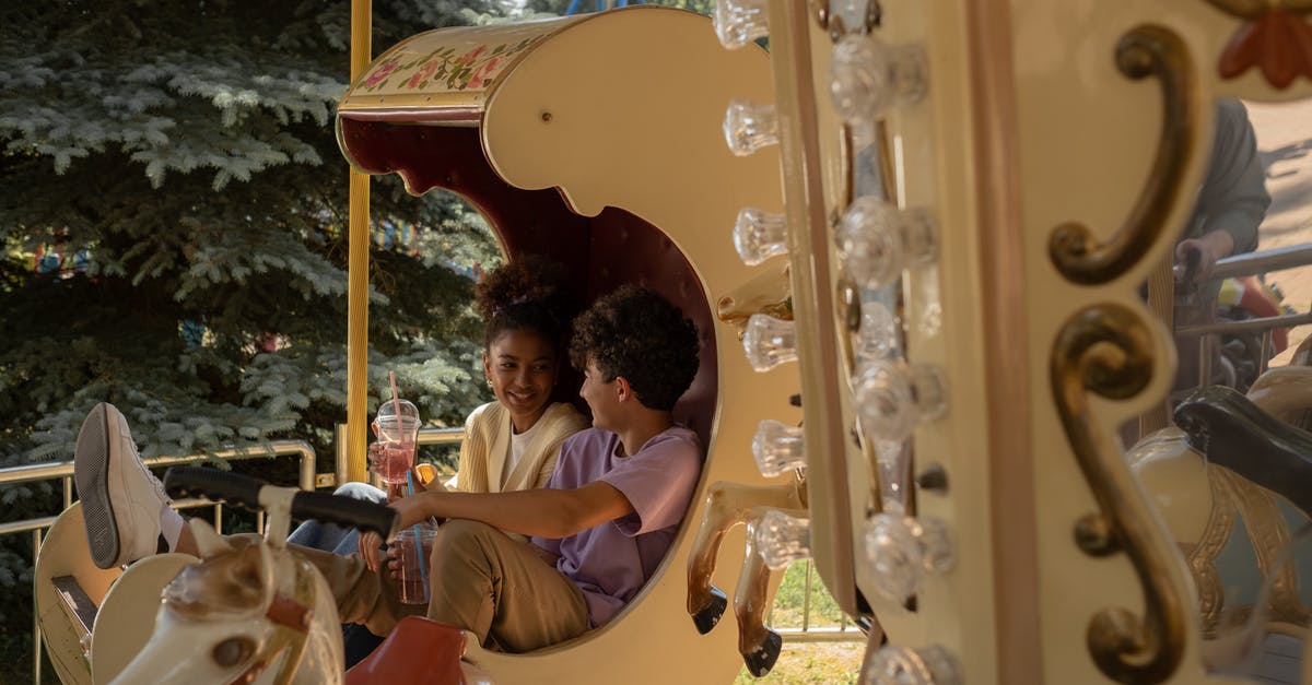 First slicing, then cooking, or the other way around? - Teenage couple sitting in carousel seat smiling and talking to each other