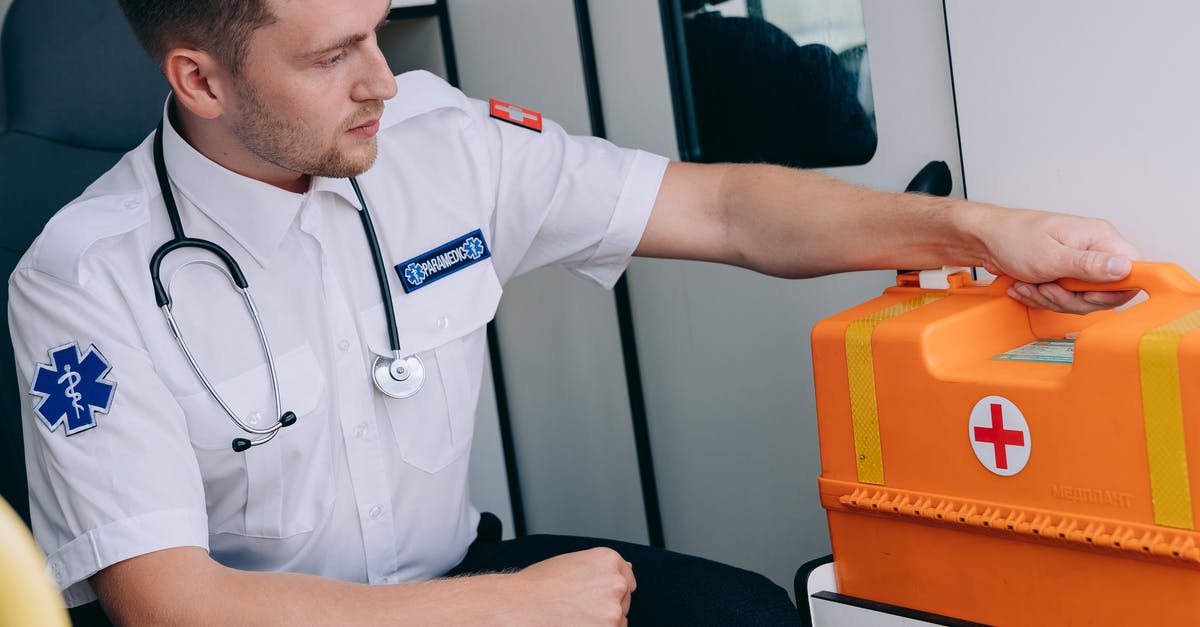 First-Aid Kit for Kitchens - A Man Sitting while Holding a First Aid Kit