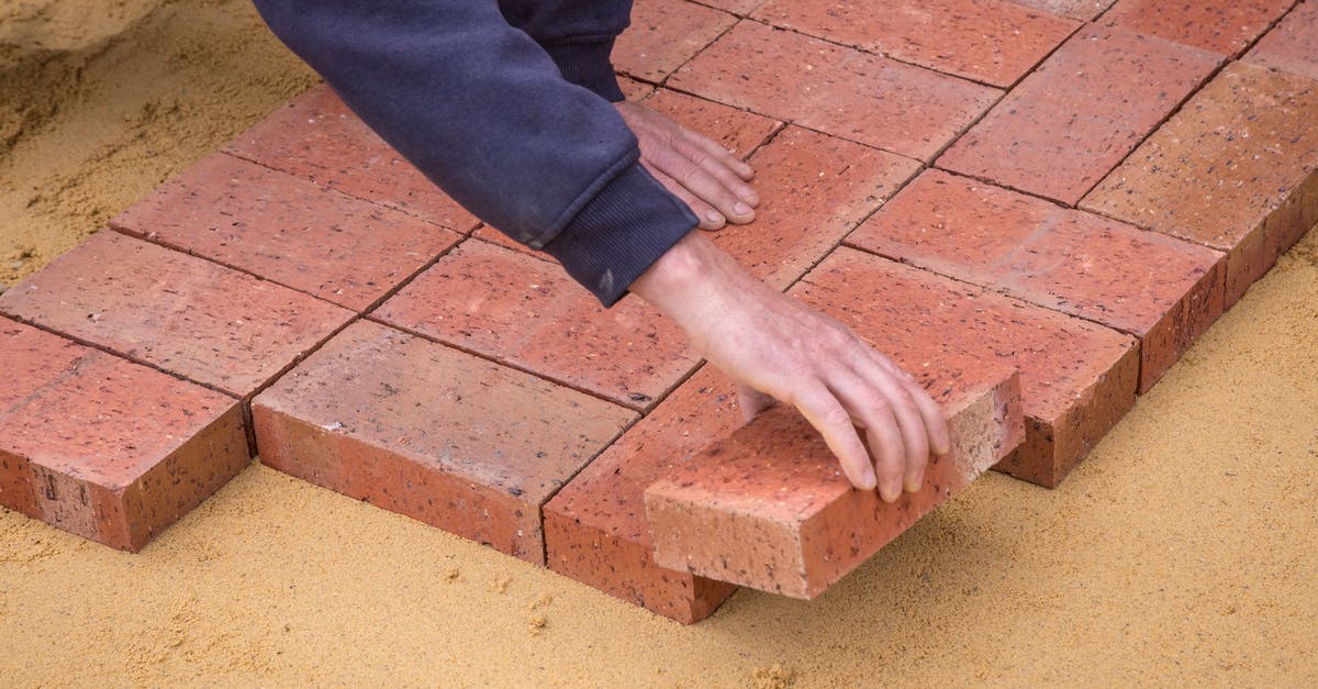 Fixing a Brownie Brick - Crop faceless man laying bricks on ground